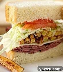 A homemade primanti brother's sandwich cut in half showing all of the sandwich ingredients.