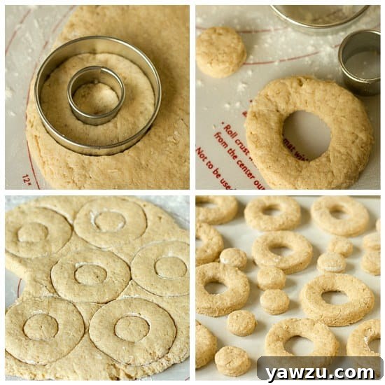 Hands using various sizes of round cookie cutters to cut out buttermilk doughnut shapes on a floured surface.