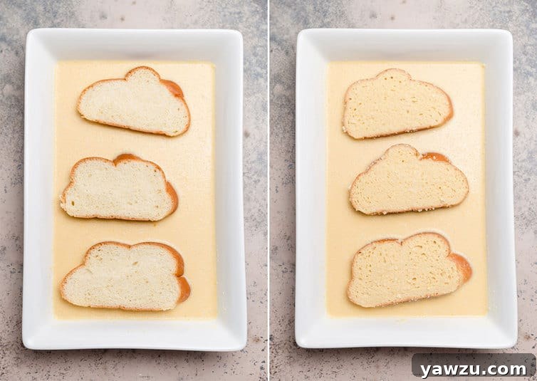 Thick slices of Challah bread soaking in a rich, creamy custard mixture in a rectangular baking dish, preparing for French toast.