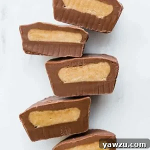 Multiple peanut butter cups cut in half, lined up, cut side up.