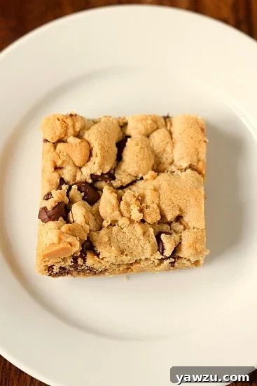 Close-up of a stack of Peanut Butter Chocolate Chip Cookie Bars, showcasing their soft texture and chocolate chips.