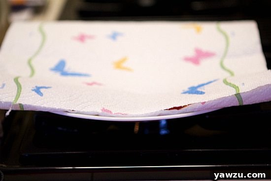 Pepperoni slices covered with a second layer of paper towels, ready for microwaving
