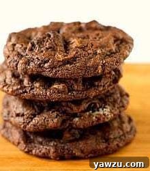 Stack of 4 triple chocolate Oreo chunk cookies on a wood board, invitingly arranged.