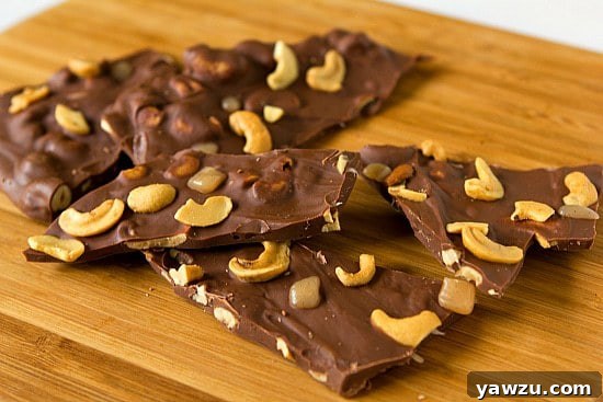 Several pieces of Salted Caramel Cashew Bark stacked, showing the layers of chocolate, caramel, and cashews