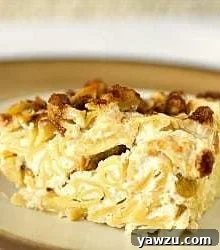 Square of noodle kugel on a cream colored plate, ready to be served.