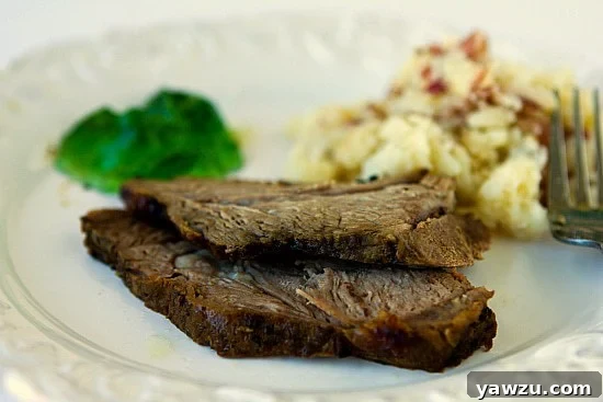 A perfectly roasted lamb joint, crusted with dark spices and herbs, ready to be sliced, on a rustic wooden board.