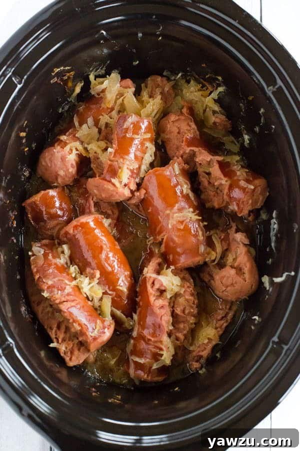 This slow cooker kielbasa and sauerkraut is flavorful and made with just the addition of beer and brown sugar - easy, delicious and perfect for parties!