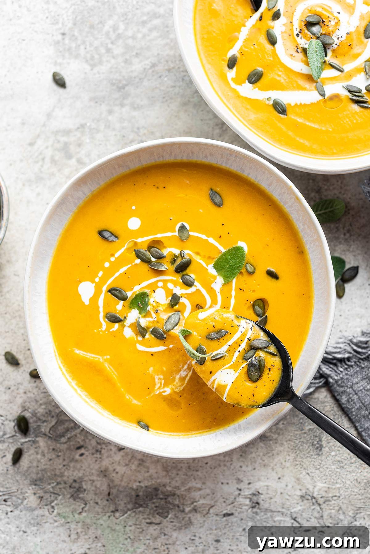 Overhead photo of pumpkin soup with spoon scooping out a spoonful.
