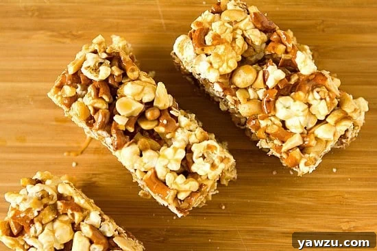 Salted Caramel Popcorn Pretzel & Peanut Bars on a wooden board, showcasing their gooey texture