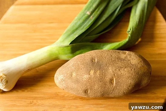 Sliced leeks and diced potatoes prepared for making a hearty soup, showcasing fresh ingredients.