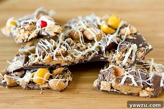 A beautifully arranged selection of colorful Halloween candies, including various chocolate bars, peanut butter cups, and M&M's, ready to be transformed into delicious bark.