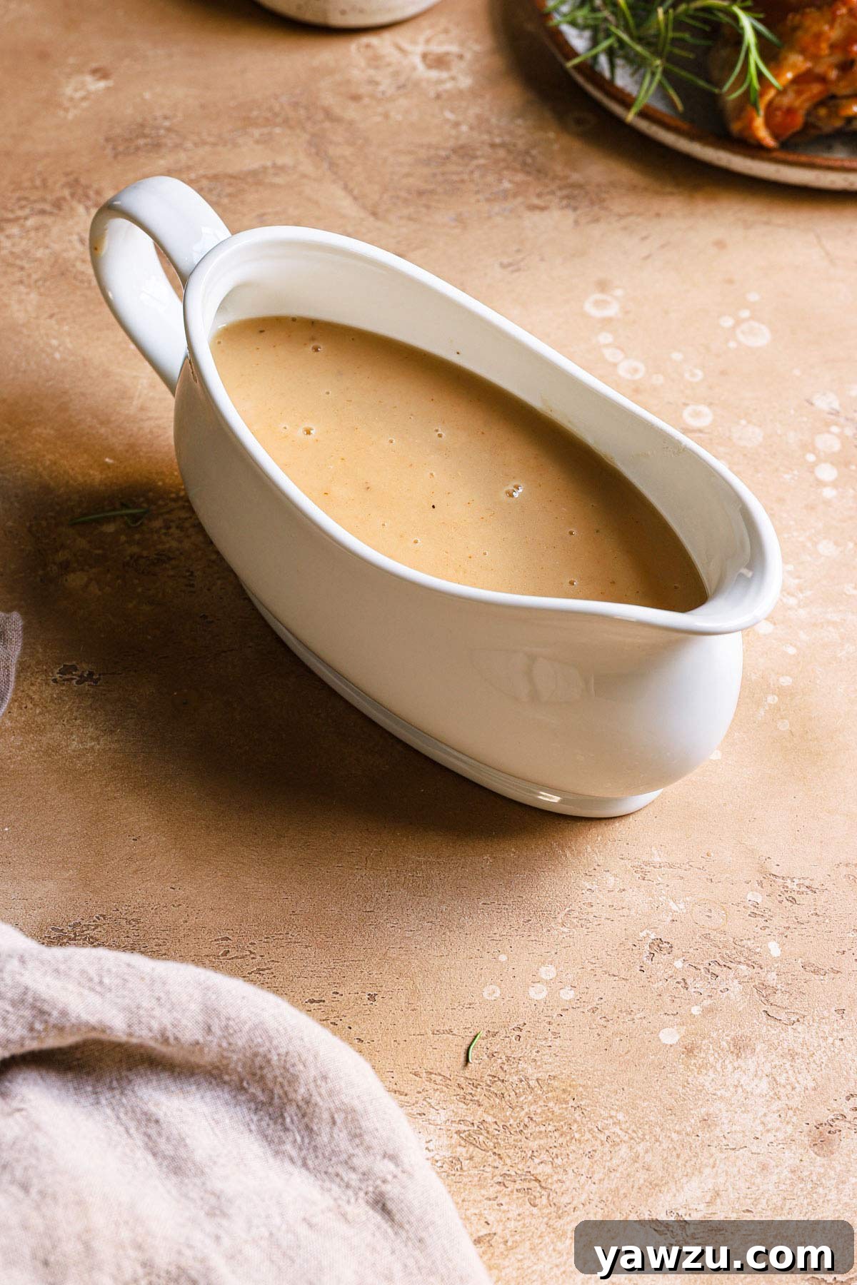 White gravy boat filled with smooth, homemade make ahead turkey gravy, ready to serve.