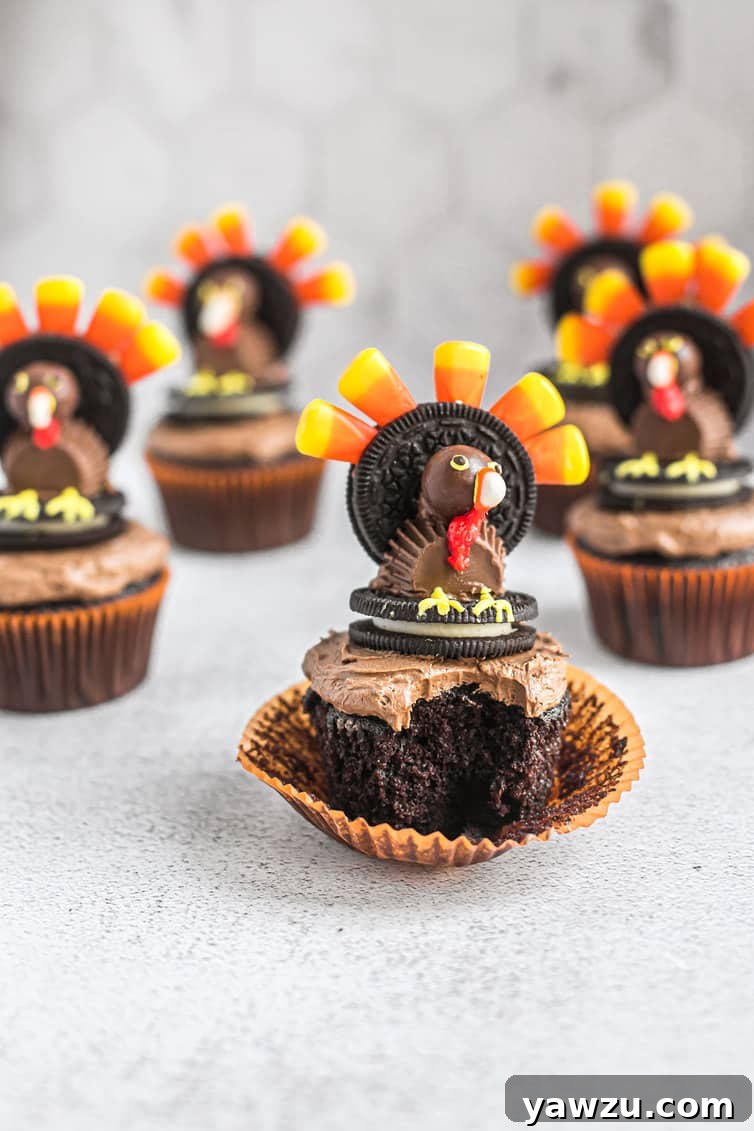 A bite taken out of chocolate cupcake with candy turkey cupcake topper.