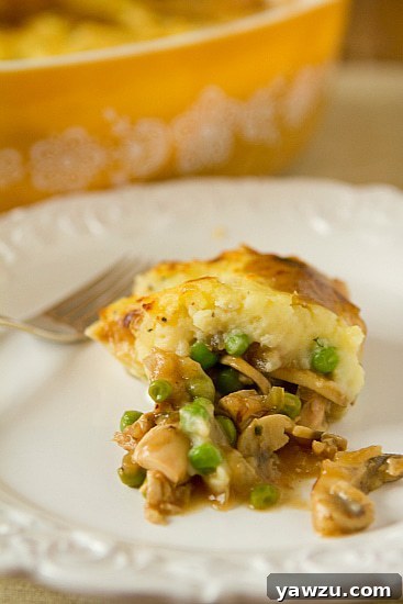 A warm, inviting Turkey Pot Pie with a golden mashed potato crust, served in a rustic dish.