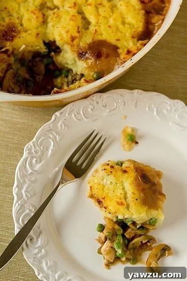 A serving of Turkey Pot Pie on a white plate, showcasing the fluffy mashed potato topping and hearty filling.