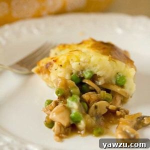 Serving of turkey pot pie on a white plate with a fork.