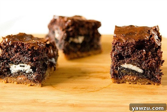 Delicious Chocolate Chip Cookie and Oreo Fudge Brownie Bar on a wooden surface