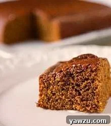 Slice of classic gingerbread cake on a white plate, ready to be enjoyed.