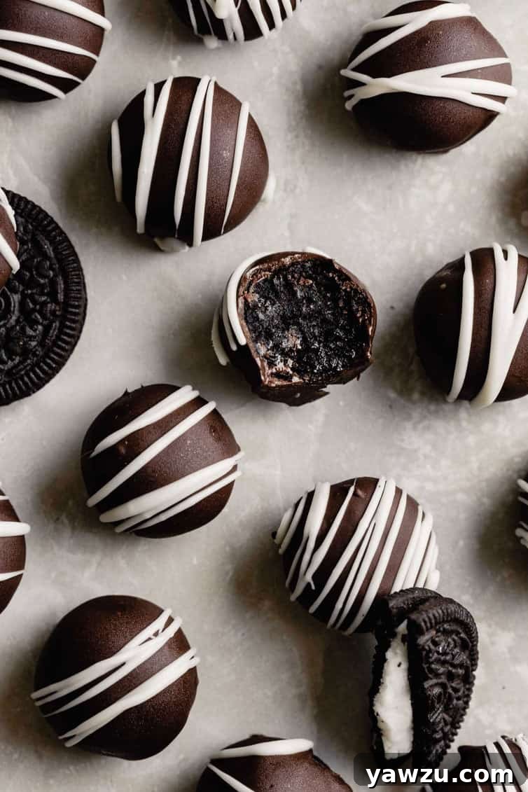 Oreo truffles on a counter with one bitten into.