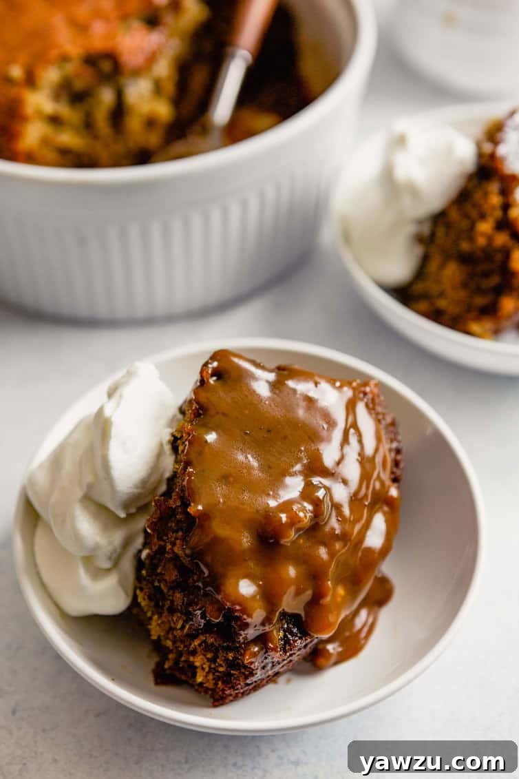 Sticky Toffee Pudding in a bowl with whipped cream.