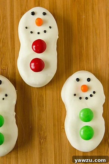 Finished Nutter Butter Snowmen arranged on a serving platter, showcasing their cute faces and M&M buttons.