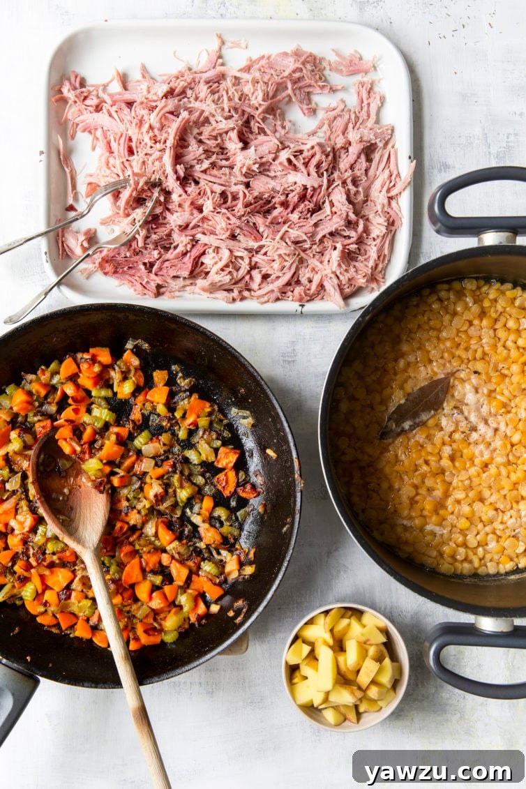 Overhead process shot of separated soup components: shredded ham, sautéed mirepoix, cooked split peas, and diced potatoes
