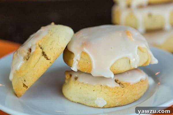A plate of freshly baked and iced Italian Walnut Pillow Cookies, ready to be enjoyed
