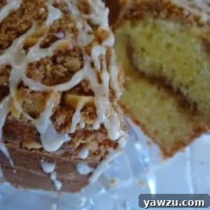 Coffee cake on a glass stand with a slice removed showing the inside.
