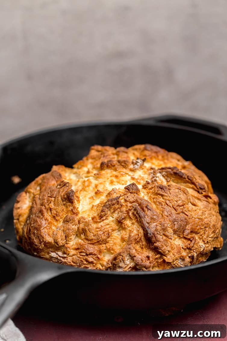 A loaf of baked Irish soda bread in a cast iron skillet.