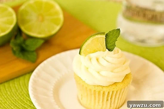Close-up of a perfectly frosted Mojito Cupcake with fresh lime and mint garnish
