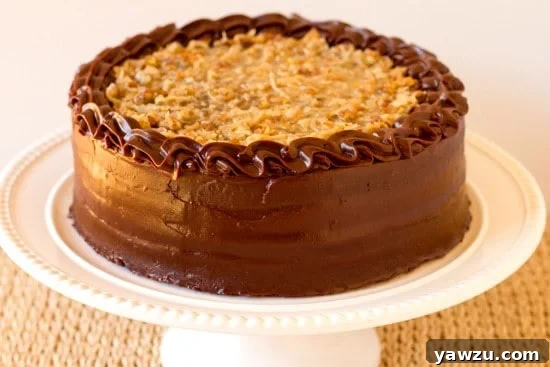 A towering slice of rich German Chocolate Cake with distinct layers of chocolate cake, pecan-coconut filling, and chocolate ganache