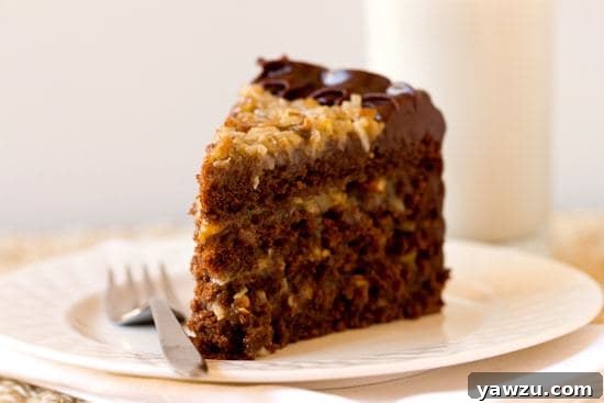 Close-up of a single slice of German Chocolate Cake, showing the moist chocolate layers, the gooey pecan-coconut filling, and the smooth chocolate frosting