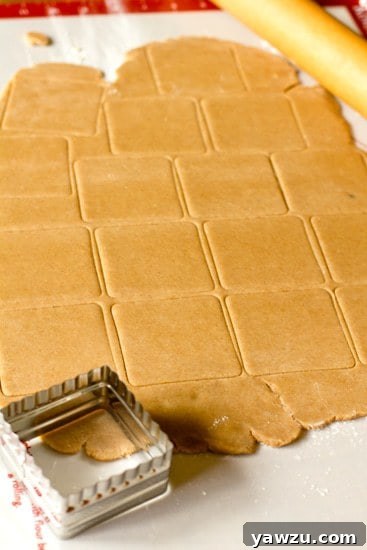 Three golden brown homemade graham crackers stacked diagonally, showcasing their rustic texture.