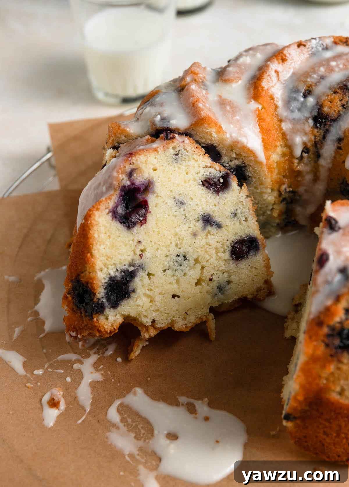 Close up photo of slice of lemon blueberry bundt cake leaning against cut side of the cake.