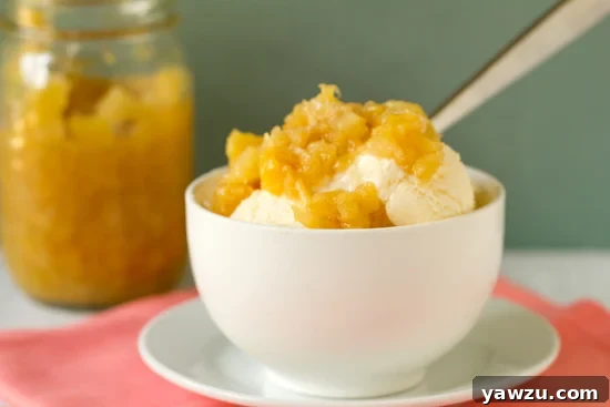 A bowl of vanilla ice cream generously topped with the homemade pineapple sauce, ready to be enjoyed.