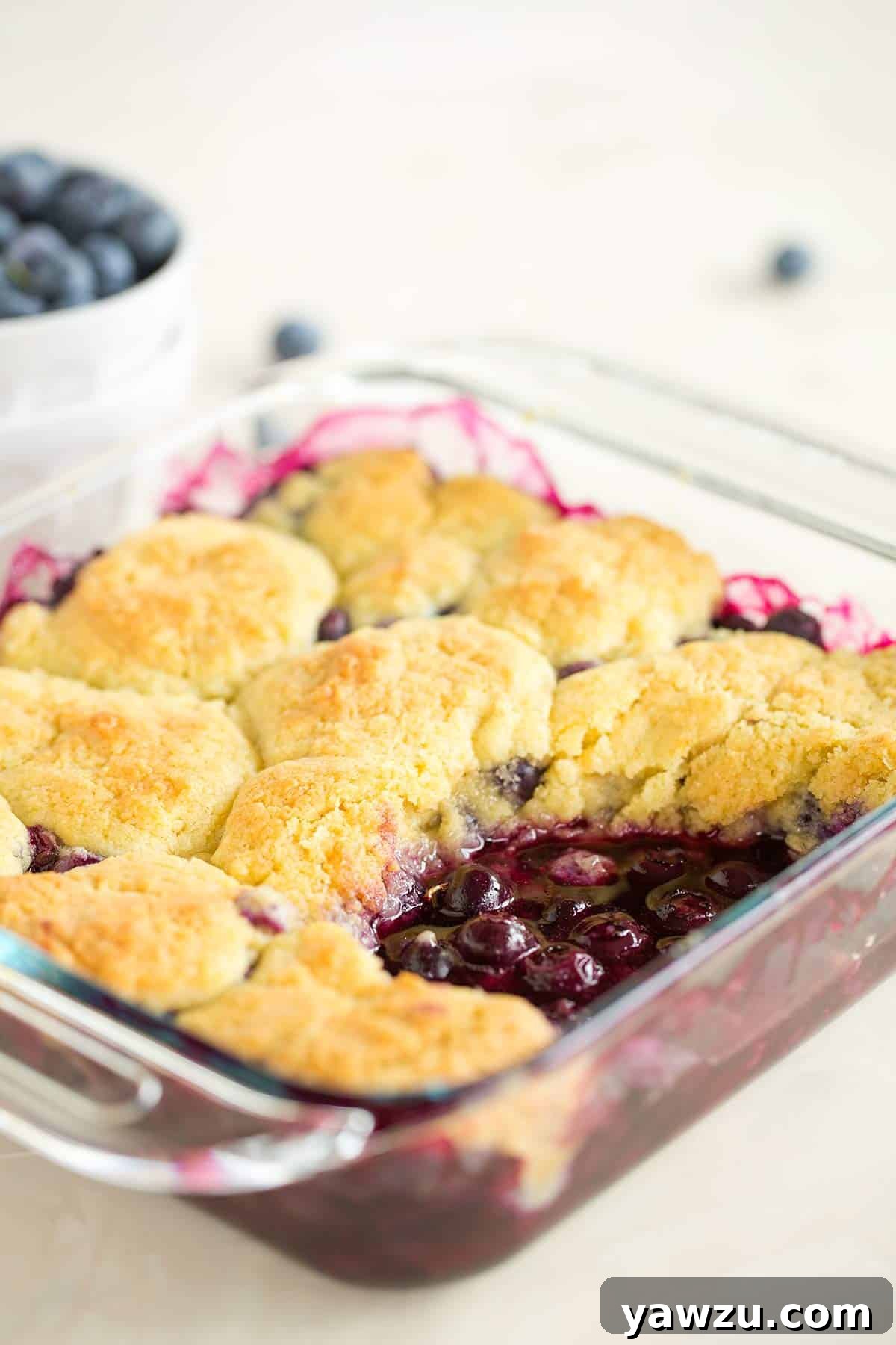 A pan of blueberry cobbler with a big scoop taken out.
