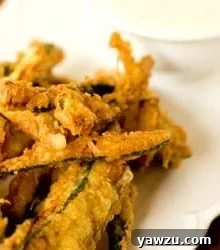 A recipe image showcasing golden beer-battered zucchini fries.