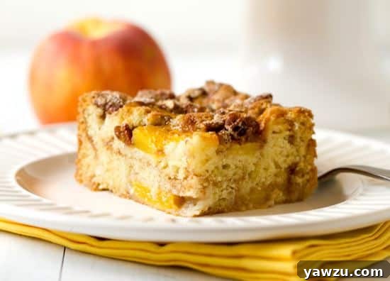 Delicious Peach Coffee Cake sliced, showcasing juicy peach pieces and a cinnamon swirl.