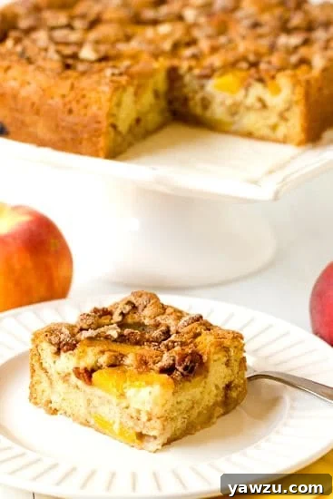 A slice of Peach Coffee Cake on a plate, highlighting the crumb and juicy peaches.