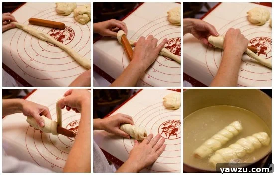 Hands wrapping pretzel dough around a hot dog on a floured surface, illustrating a step in the preparation process.