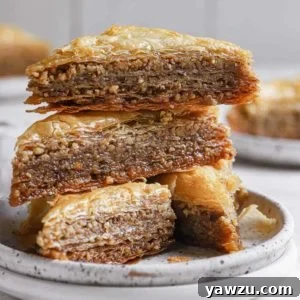 A stack of 3 slices of baklava on a white plate.