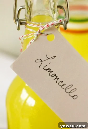 Close-up of a filled bottle of homemade Limoncello with a lemon slice