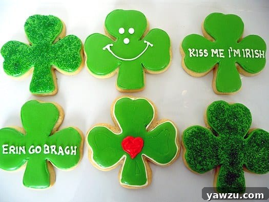 A festive display of six shamrock sugar cookies, each meticulously decorated with vibrant green icing and intricate piping, presented on a pristine white plate, celebrating St. Patrick's Day.