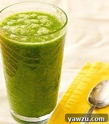 A glass of green smoothie with ice, ready to be enjoyed.