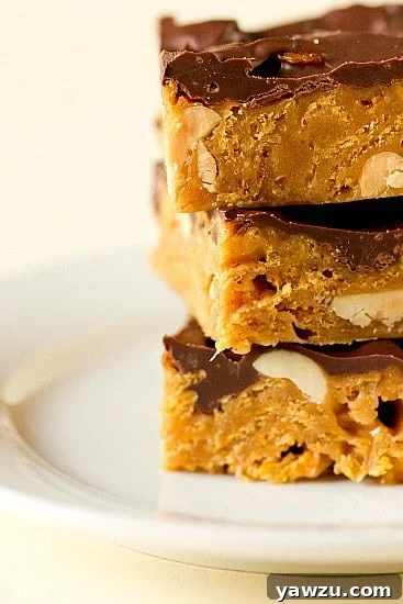 Delicious Goody Goody Bars stacked on a plate, showcasing their rich peanut and chocolate layers