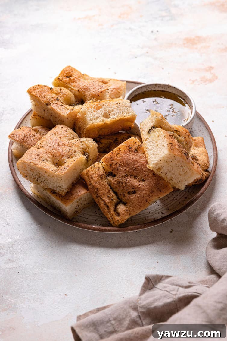 A small plate with sliced focaccia and a small bowl of herb oil.