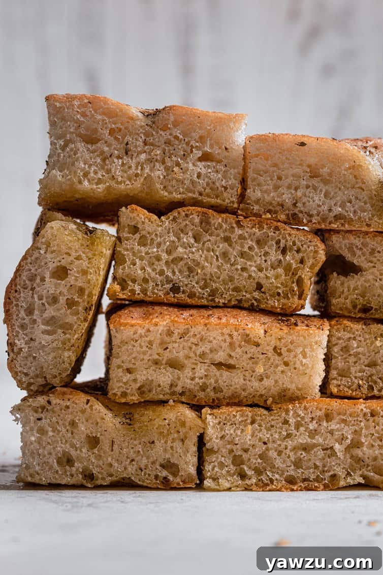 A stack of sliced focaccia layered like bricks on a white counter.