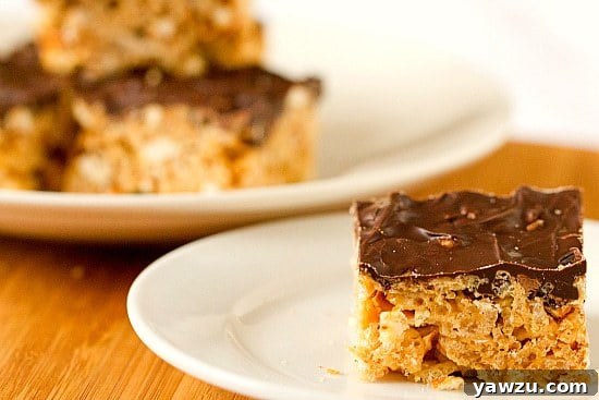 Close-up of Chubby Hubby Rice Krispies Treats showing the texture of cereal, pretzels, and peanut butter chips under a layer of chocolate.