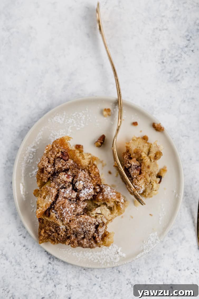 An overhead photo of French toast casserole on a plate, garnished with powdered sugar and berries.
