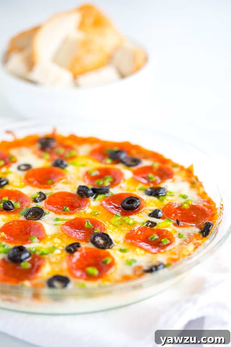 A pie plate with pizza dip and a bowl of bread cubes for dipping.